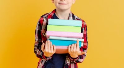 ragazzino-di-vista-frontale-con-la-pila-di-libri